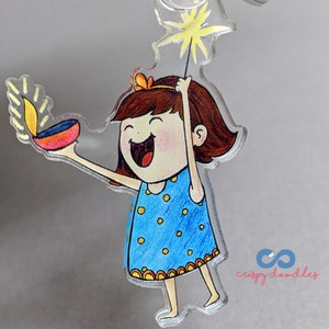 ディワリキーチェーン - 女の子とディヤと花火 ディワリの記念品で光の祭りを祝いましょう 贈り物に最適です