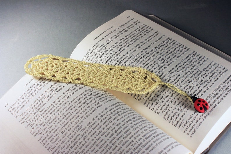 A lovely light yellow crocheted bookmark with a ladybug attached. This bookmark's little ladybug will help you keep your place and give you a smile. Great for gift giving or for yourself. Perfect for the reader in your life.