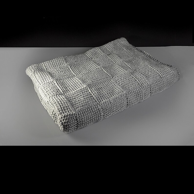 May include: A gray knitted throw blanket with a checkered pattern.