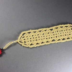 A lovely light yellow crocheted bookmark with a ladybug attached. This bookmark's little ladybug will help you keep your place and give you a smile. Great for gift giving or for yourself. Perfect for the reader in your life.