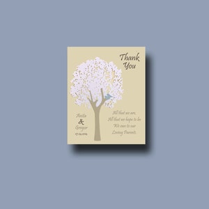 May include: A beige thank you card with a white paper cut-out tree and a blue bird. The text reads "Thank You" and "Anita & Gregor 07.24.2014" and "All that we are, All that we hope to be We owe to our Loving Parents."