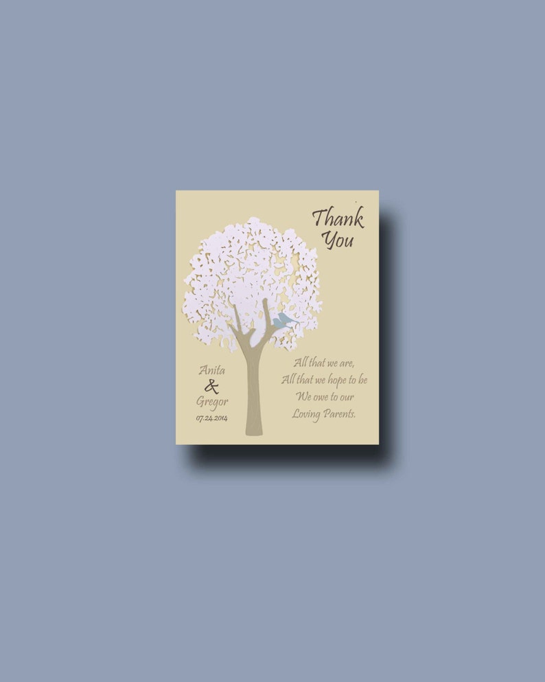 May include: A beige thank you card with a white paper cut-out tree and a blue bird. The text reads "Thank You" and "Anita & Gregor 07.24.2014" and "All that we are, All that we hope to be We owe to our Loving Parents."