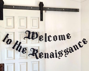 May include: Black banner with the words "Welcome to the Renaissance" in a gothic font, strung across a white door. The banner is suspended by thin silver wires.