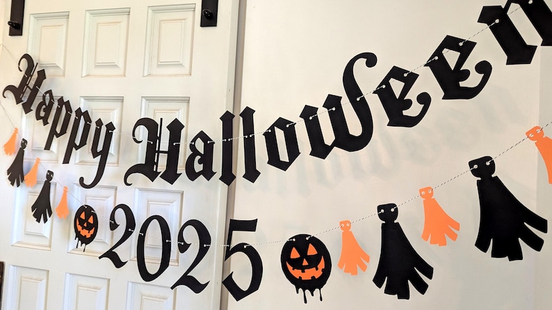 May include: A Halloween banner with the words "Happy Halloween 2025" in black gothic lettering. The banner includes orange and black decorative cutouts of pumpkins and ghosts, strung on a white string, perfect for Halloween decorations.