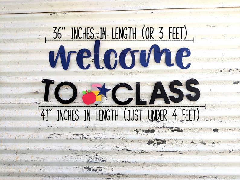 Może przedstawiać: Baner klasowy z napisem "welcome TO CLASS" w kolorze granatowym i czarnym. G&oacute;rny baner ma 91 cm długości, a dolny 104 cm. Baner zawiera czerwone jabłko, ż&oacute;łty oł&oacute;wek i niebieską gwiazdę.