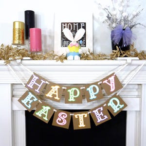 May include: A festive Easter banner with the words "HAPPY EASTER" in colorful letters hangs above a fireplace. The mantel is decorated with candles, a bunny figurine, and floral accents, creating a cheerful holiday display.