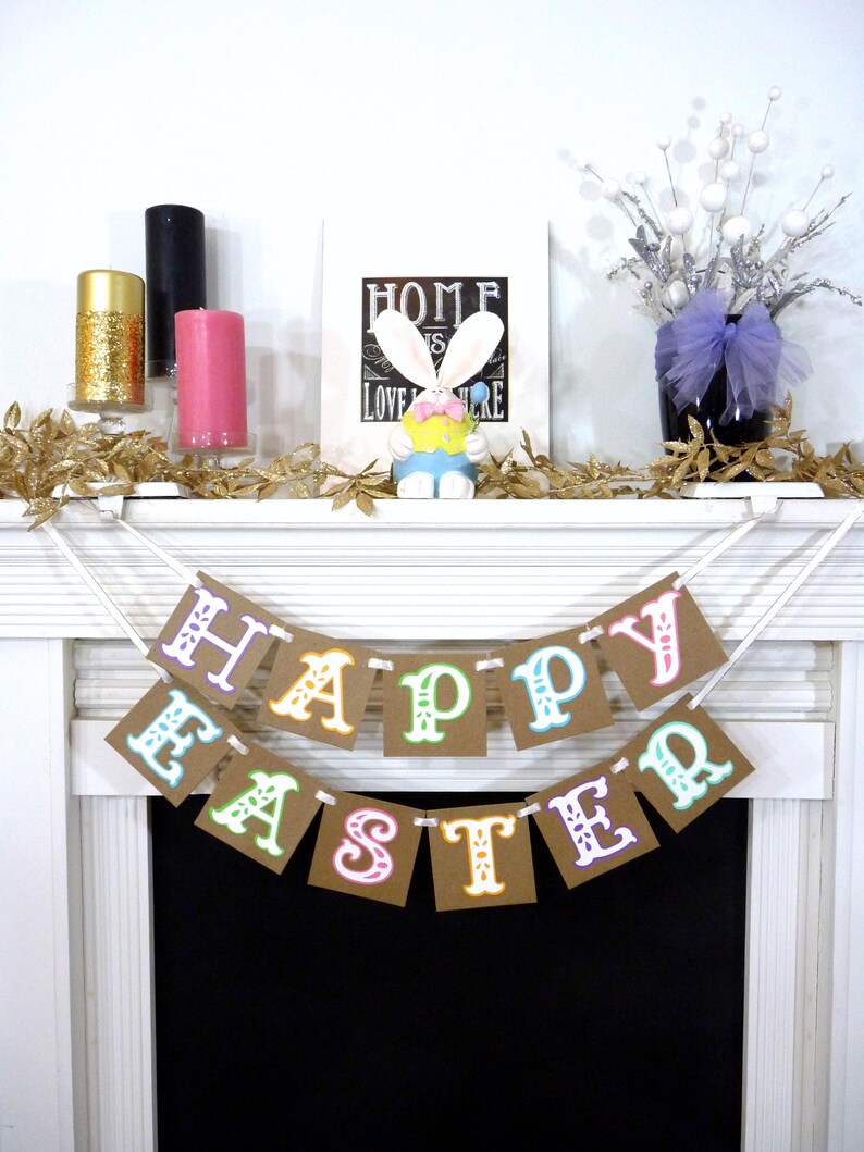 May include: A festive Easter banner with the words "HAPPY EASTER" in colorful letters hangs above a fireplace. The mantel is decorated with candles, a bunny figurine, and floral accents, creating a cheerful holiday display.