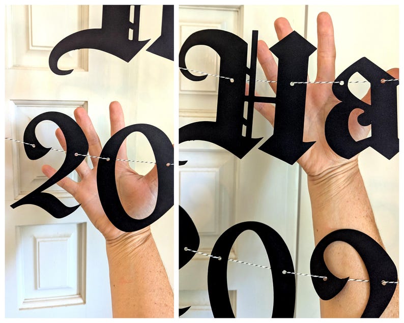 May include: Black paper banner spelling out "Happy 2023" in a gothic font. The numbers and letters are strung together with white and gray twine. The banner is held up in front of a white door.