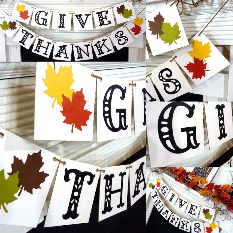 May include: A festive banner with the words "GIVE THANKS" in black, decorative lettering. The banner is strung with twine and adorned with colorful leaf cutouts in shades of red, yellow, and brown, perfect for autumn decor.
