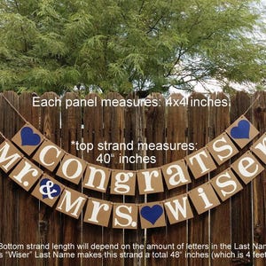 May include: A banner with the words "Mr. & Mrs. Congrats Wiser" in white letters on brown rectangular panels. Each panel is 4x4 inches. Blue hearts accent the design. The top strand measures 40 inches.