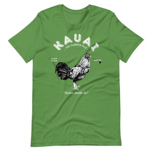 May include: Green t-shirt with a white graphic of a rooster and the text "Kauai - The Garden Isle" with the words "Aloha Kekoa" and "Hawaii" on either side of the rooster. The text "Shaka doodle do!" is below the rooster.