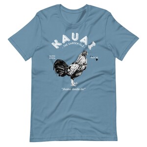 May include: A light blue t-shirt with a white graphic of a rooster and the text "Kauai - The Garden Isle - Aloha Kekoa - Hawaii - Shaka doodle doi!"