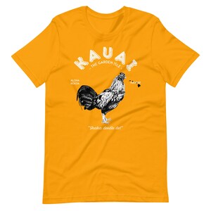 May include: Yellow t-shirt with a black and white rooster illustration. The text "Kauai - The Garden Isle -" is above the rooster. The text "Aloha Kekoa" is to the left of the rooster and "Hawaii" is to the right. The text "Shaka doodle do!" is below the rooster.
