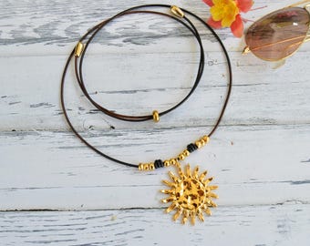 Gouden ketting met zonnehanger: dik leren koord statement sieraden