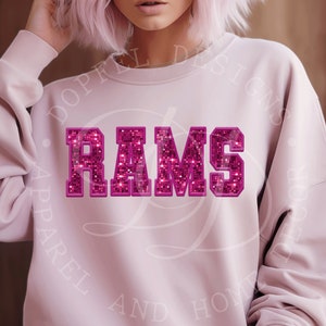 May include: Pink sweatshirt with the word "RAMS" in large, pink glitter letters.