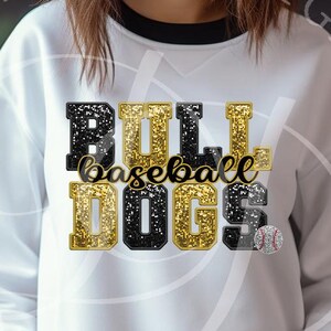 May include: White sweatshirt with black and gold glitter lettering that reads "Bull Baseball Dogs".