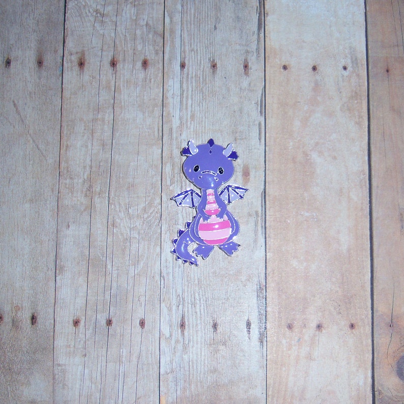 May include: Purple and pink cartoon dragon figurine with a striped body and wings.