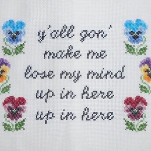 Pode incluir: Bordado de ponto de cruz com fundo branco e texto preto que diz "y'all gon' make me lose my mind up in here up in here". O texto é rodeado por pensamentos bordados coloridos.