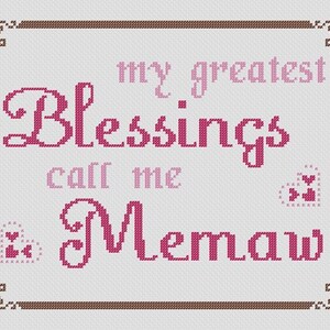 May include: Cross-stitch design with the words "my greatest Blessings call me Memaw" in shades of pink. The design includes decorative corner elements and heart accents, all on a white background.
