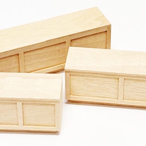 Op de afbeelding: Drie houten dozen met deksels en twee compartimenten elk. De dozen zijn van verschillende grootte en zijn op elkaar gestapeld.