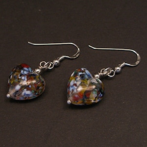 May include: A pair of silver heart-shaped earrings with colorful glass beads. The beads are a mix of white, blue, red, green, and yellow.