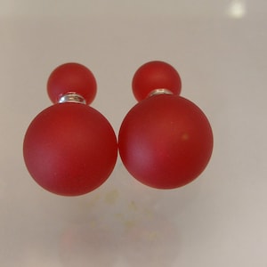 May include: A pair of red double-sided stud earrings. Each earring has two round red beads.
