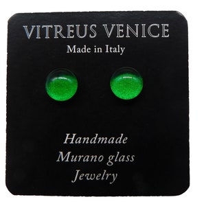 Puede incluir: Un par de pendientes de vidrio verde con un acabado brillante. Los pendientes son hechos a mano de vidrio de Murano y dicen "Vitreus Venice Made in Italy" en la tarjeta negra en la que se muestran.