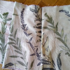 May include: Three pieces of white fabric with a floral print of green and grey leaves. The fabric has a subtle pink hue.