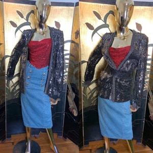 May include: A black sequined blazer with a red satin top and a blue denim skirt. The blazer has a tie at the waist.