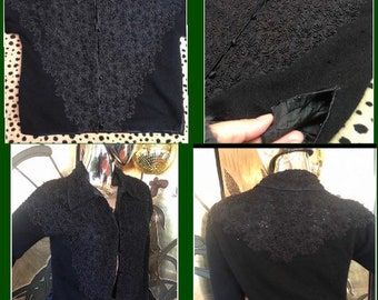 May include: Black button-down shirt with intricate floral embroidery on the front and collar. The short-sleeved top features a collared neckline and a tailored fit. The shirt is made of a soft, dark fabric.