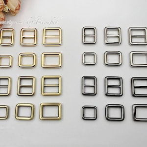 May include: Assortment of gold and silver metal D-ring buckles in various sizes. The buckles are arranged in rows on a white background.