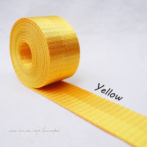 May include: A roll of bright yellow webbing, a type of strong, woven nylon fabric, often used for straps, belts, and other applications. The text "Yellow" is written below the webbing.
