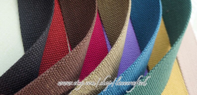 May include: A variety of woven cotton webbing in different colors, including black, red, brown, beige, purple, teal, green, and yellow. The webbing is arranged in a fan shape, with the ends of each strip overlapping. The text "www.etsy.com/shop/lacecrafted" is visible at the bottom of the image.