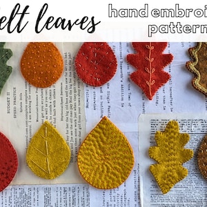 Puede incluir: Una colección de hojas de fieltro en varios colores y formas, incluyendo verde, naranja, rojo y marrón. Cada hoja está bordada a mano con un patrón de puntadas diferente. Las hojas están dispuestas sobre un trozo de papel con el texto "felt leaves hand embroidery pattern".