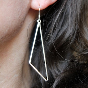 May include: Silver triangle dangle earrings with a simple geometric design.
