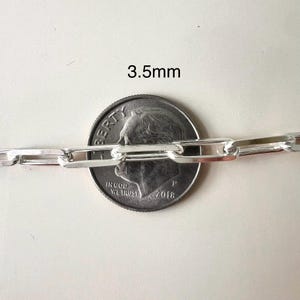 May include: Close-up of a silver chain necklace with a 3.5mm width. The chain is shown next to a US dime for size comparison.