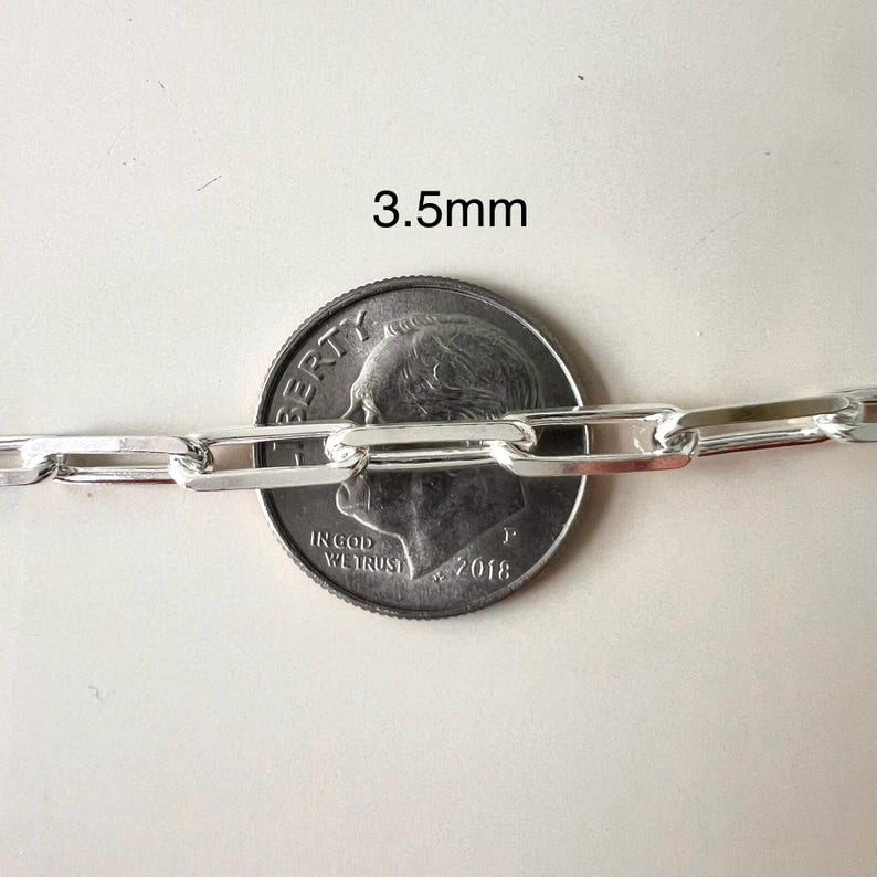 May include: Close-up of a silver chain necklace with a 3.5mm width. The chain is shown next to a US dime for size comparison.