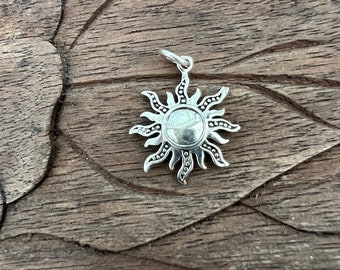 May include: Silver sun charm pendant with a detailed design. The sun has a textured surface and a loop at the top for attaching to a chain or bracelet.