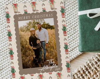 May include: A Christmas card with a family photo inside a scalloped frame. The card has a beige background with a pattern of cowboy boots, cacti, and arrows. The text "MERRY CHRISTMAS" is at the top, and "The Albrights 2024" is at the bottom.