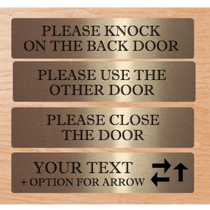 Pode incluir: Quatro placas de metal douradas com texto preto. A placa superior diz "PLEASE KNOCK ON THE BACK DOOR". A segunda placa diz "PLEASE USE THE OTHER DOOR". A terceira placa diz "PLEASE CLOSE THE DOOR". A placa inferior diz "YOUR TEXT + OPTION FOR ARROW" com setas apontando para a esquerda, direita e para cima.