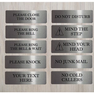 May include: Ten silver metal signs with black text. The signs have various messages, including "Please Close the Door", "Do Not Disturb", "Mind the Step", "Mind Your Head", "Please Ring the Bell", "Please Ring the Bell & Wait", "Please Knock", "No Junk Mail", "No Cold Callers", and "Your Text Here".