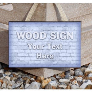 Può includere: Un cartello di legno bianco con uno sfondo di muro di mattoni. Il cartello dice "WOOD SIGN Your Text Here".