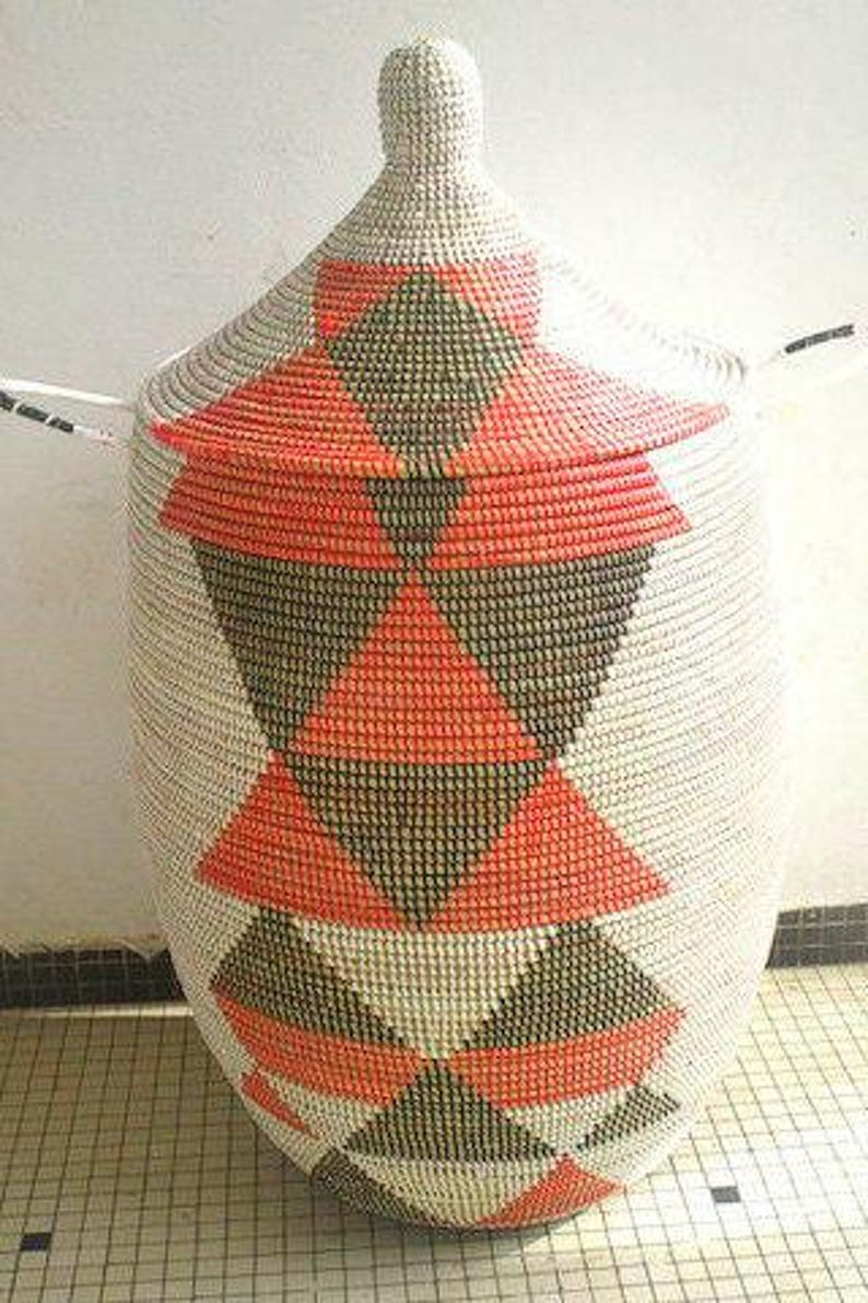 May include: A large, white woven basket with a lid. The basket has a geometric pattern of red and black triangles.