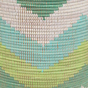 May include: A woven basket with a geometric pattern in shades of green, blue, and white. The basket is made of natural materials and has a round shape.