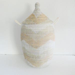 May include: A white and beige woven storage basket with a lid and two handles. The basket has a geometric pattern.