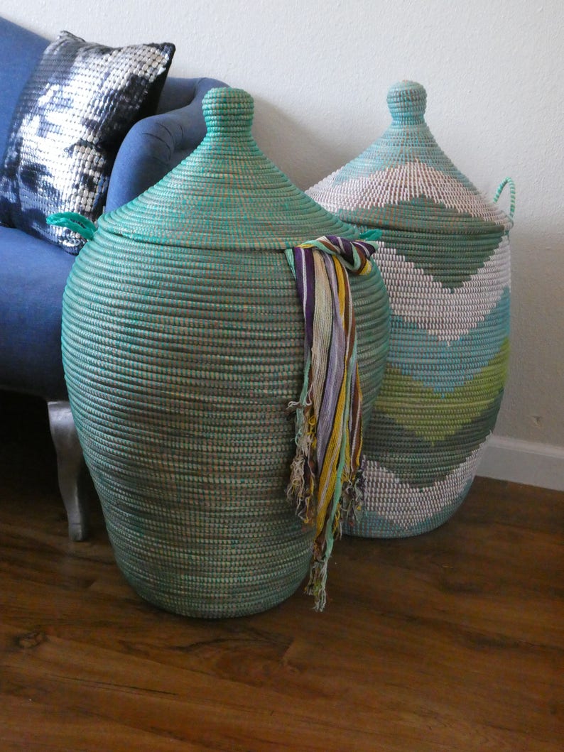 May include: Two large woven storage baskets with lids. The basket on the left is teal green and the basket on the right is white, green, and blue.