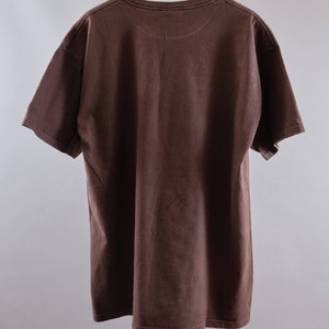 May include: A brown t-shirt with a crew neck and short sleeves.