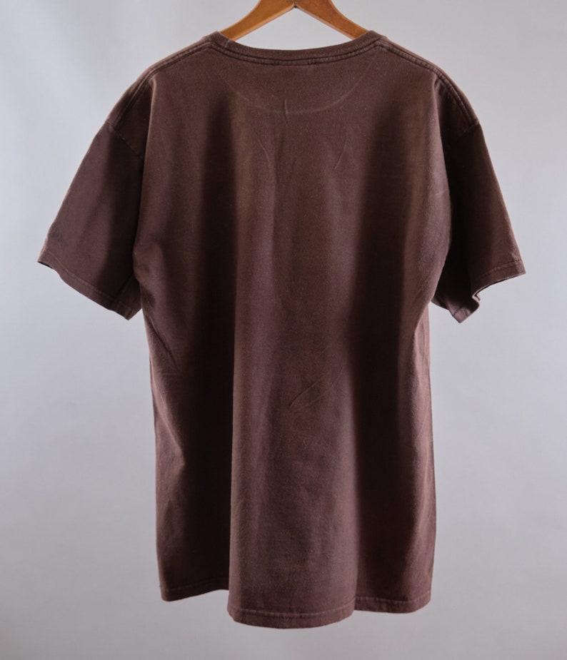 May include: A brown t-shirt with a crew neck and short sleeves.