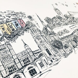 May include: Black and white ink drawing of a city skyline with a church, buildings, and trees. The drawing is done in a minimalist style and features a few colorful accents.