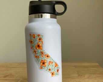 May include: White stainless steel water bottle with a black lid and handle. A sticker of the state of California with orange poppy flowers is on the bottle.